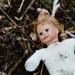 girl in white long sleeve shirt lying on dried leaves