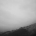 grayscale photography of fog covered mountain