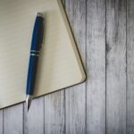 blue click pen on brown wooden table