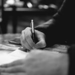 person writing on white paper