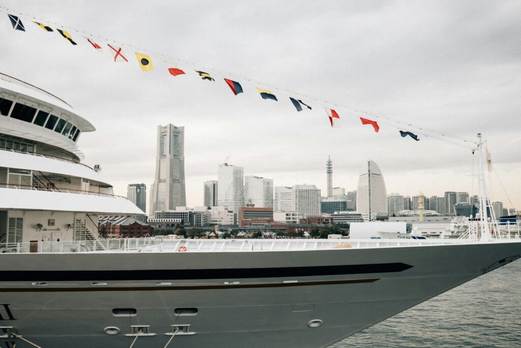 A large yacht sails with city skyline in the background